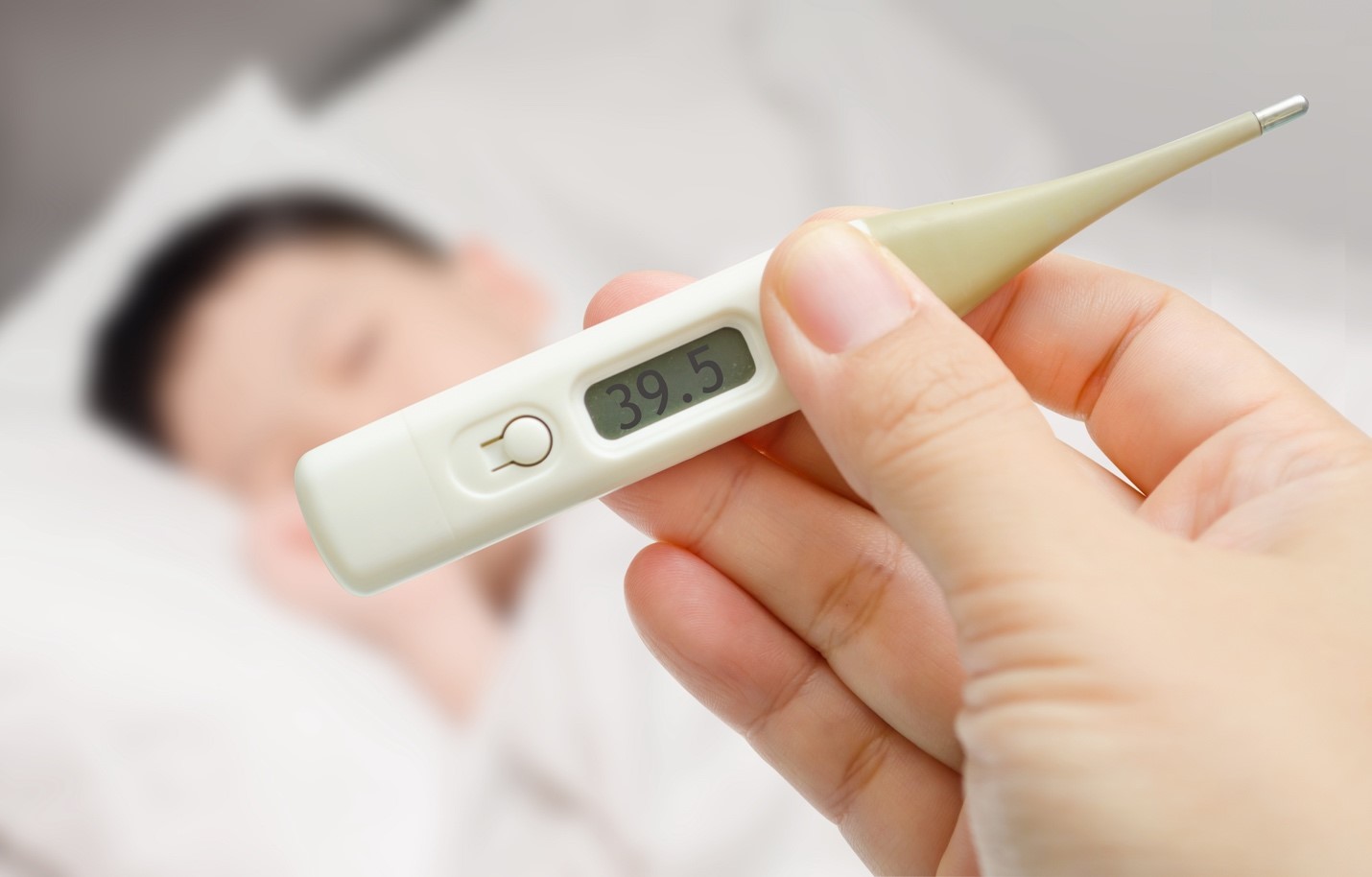 Ibu yang memeriksa suhu tubuh anaknya dengan termometer digital, mengawasi perkembangan demam anaknya dengan cermat