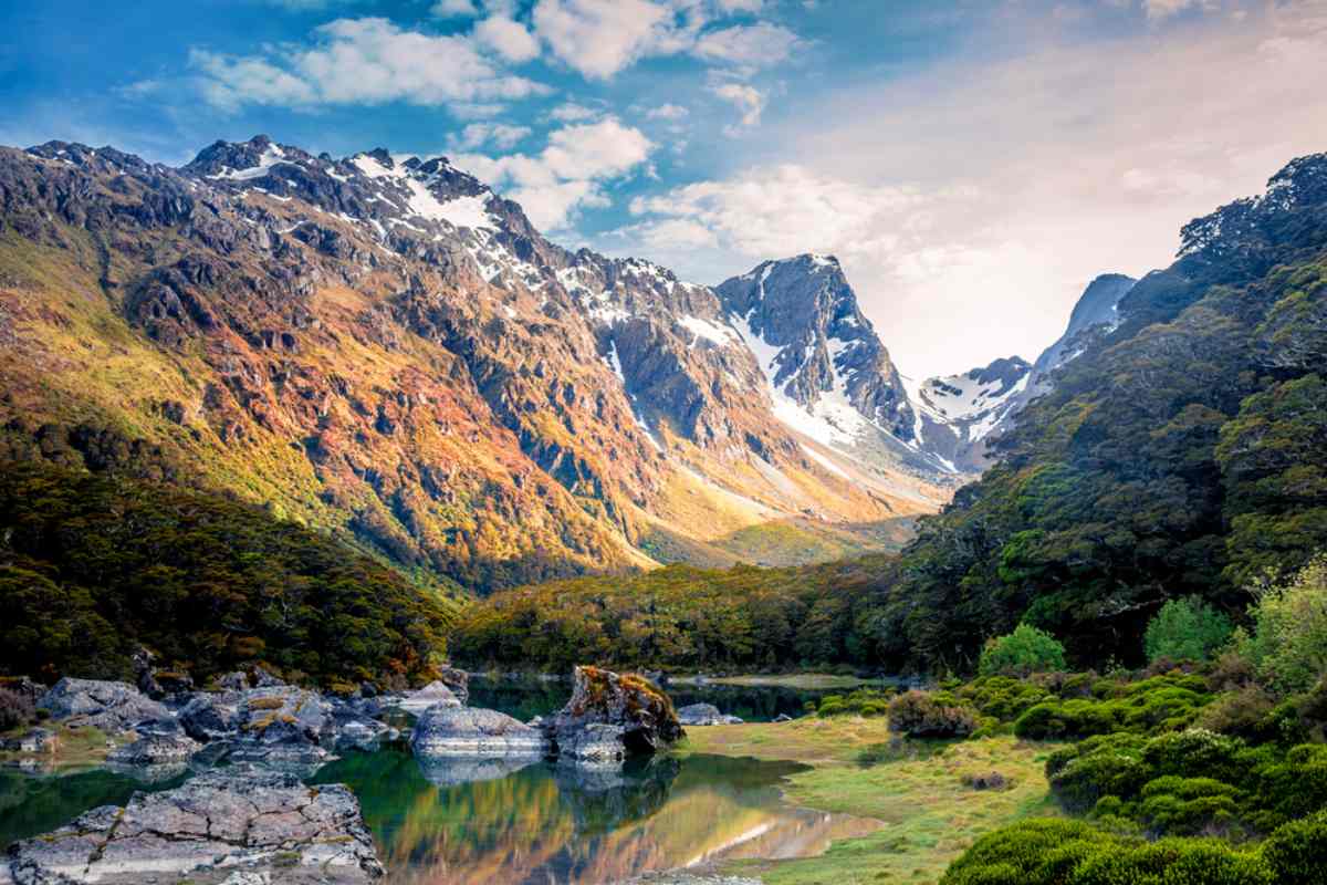 An aerial view of the rugged mountains and pristine valleys of Fiordland National Park, showcasing its natural beauty.